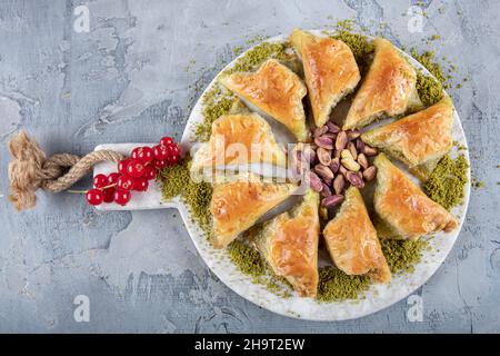 Primo piano del tradizionale dessert turco Ramadan - baklava con pistacchi (turco: Sobiyet baklava) di fronte ad altri tipi diversi di baklava. EI Foto Stock