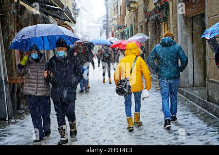 La città è stata coperta da una tempesta di neve, freddo, cambiamenti climatici, la gente sta camminando sotto la tempesta di neve. Aosta, Italia - Dicembre 2021 Foto Stock