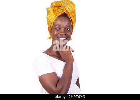 bella giovane donna che posa su sfondo bianco e tenendo il dito sulla guancia sorridente. Foto Stock