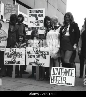 1970s, storico, gruppo di persone, principalmente donne, con striscioni e cartelli, facendo una protesta fuori da un centro commerciale circa il fallimento del Southwark Consiglio di offrire libero controllo delle nascite e contraccezione. Un poster dice: "Outhwark spende più sul controllo del ratto che sul controllo delle nascite". La capacità delle giovani donne non sposate di accedere alla contraccezione e prevenire i premessi indesiderati è rimasta limitata fino alla fine del 1970s. Foto Stock