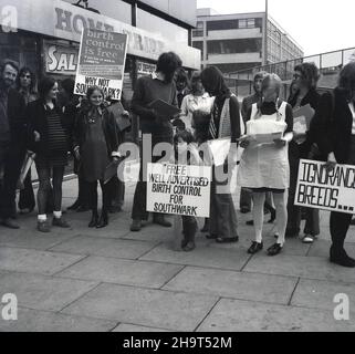 1970s, storico, gruppo di persone, principalmente donne, con striscioni e cartelli, facendo una protesta fuori da un centro commerciale circa il fallimento del Southwark Consiglio di offrire libero controllo delle nascite e contraccezione. Un poster dice: "Outhwark spende più sul controllo del ratto che sul controllo delle nascite". La capacità delle giovani donne non sposate di accedere alla contraccezione e prevenire i premessi indesiderati è rimasta limitata fino alla fine del 1970s. Foto Stock