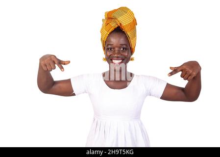 bella giovane donna africana puntando entrambe le dita verso il basso e guardando la macchina fotografica sorridente. Foto Stock