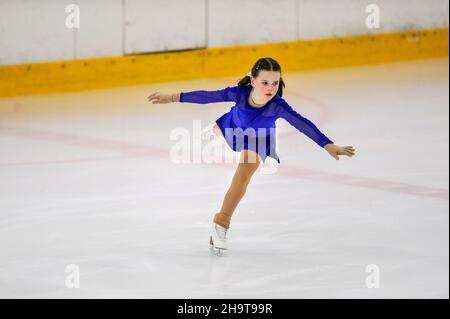 Piccola ragazza figura skater pattinaggio su ghiaccio al coperto Foto Stock