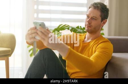 Uomo che fa selfie foto con la fotocamera istantanea. Foto Stock