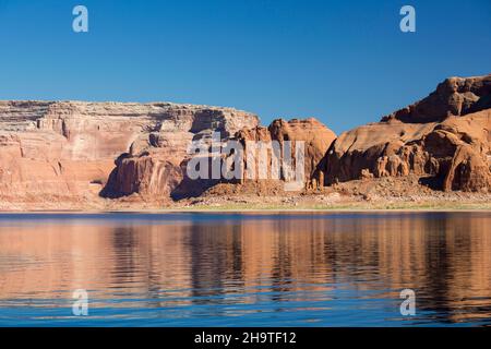 Glen Canyon National Recreation Area, Utah, USA. Alte scogliere di arenaria rossa riflesse nelle acque tranquille del Lago Powell. Foto Stock