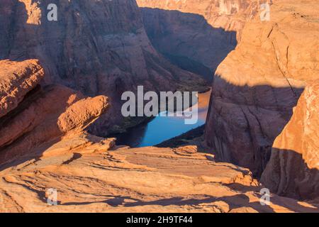 Glen Canyon National Recreation Area, Page, Arizona, Stati Uniti. Vista dalla cima della scogliera sul tranquillo fiume Colorado all'Horseshoe Bend, all'alba. Foto Stock