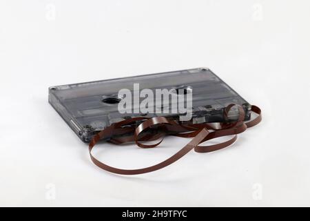 Nastro per cassette per un vecchio riproduttore di cassette su sfondo bianco. Messa a fuoco selettiva. Foto Stock