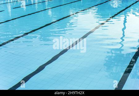 Primo piano per la calma acqua della piscina, corsie di nuoto visibili a fondo piastrellato Foto Stock