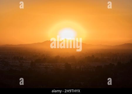 Sunrise dietro il monte Hollywood e il monte Lee all'estremità est delle montagne di Santa Monica nell'area di Griffith Park di Los Angeles, California. Foto Stock