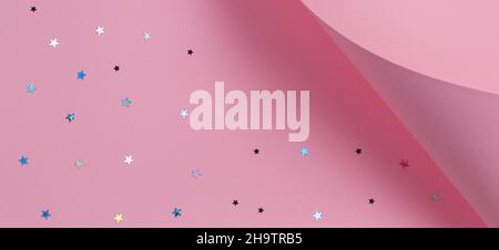 Carta color rosa pastello di forma geometrica con stella glitterata. Natale astratto, sfondo di Capodanno Foto Stock
