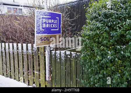 Mattoni viola on-line agente immobiliare venduto segno con neve. Foto Stock