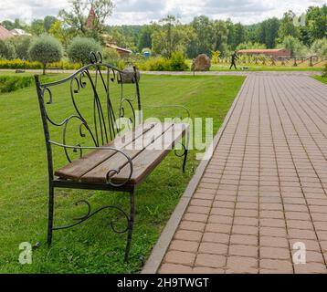 Sula Village, 14, distretto di Stolbtsovsky, regione di Minsk, Bielorussia. Agosto 9, 2019. Panca di legno con una bella schiena e passerella a Sula. Foto Stock