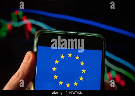 Cina. 09th Dic 2021. In questa foto è mostrata la bandiera dell'Unione europea (UE) visualizzata su uno smartphone con un grafico dell'indice delle borse economiche sullo sfondo. (Foto di Budrul Chukrut/SOPA Images/Sipa USA) Credit: Sipa USA/Alamy Live News Foto Stock