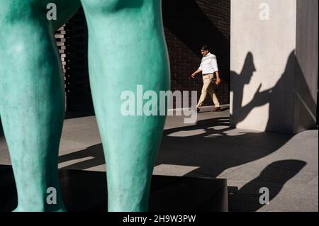 '24.05.2018, Singapore, , Singapore - Un uomo passa davanti al gruppo scultoreo di figure 'la Recontre' (il Meeting) dell'artista francese Etienne Pirot Foto Stock