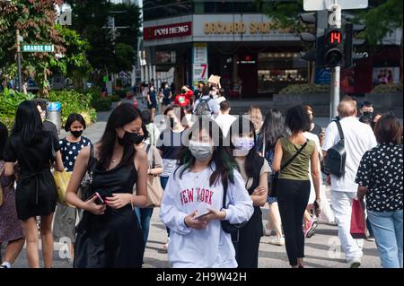 '12.11.2021, Singapore, Singapore - i pedoni che indossano le guardie della bocca camminano lungo Orchard Road nel centro della città in mezzo alla pandemia di Corona in corso (Co Foto Stock