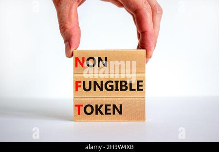 Simbolo token non fungibile NFT. Concetto parole NFT non-fungibile token su blocchi di legno. Bella sfondo bianco, mano uomo d'affari, spazio copia. Autobus Foto Stock