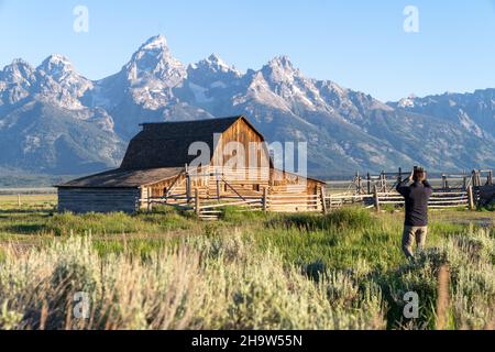 Wyoming, USA - 28 giugno 2021: Tourist Man scatta foto di John Moulton Barn a Mormon Row nel Grand Teton National Park in una mattinata limpida e soleggiata in su Foto Stock