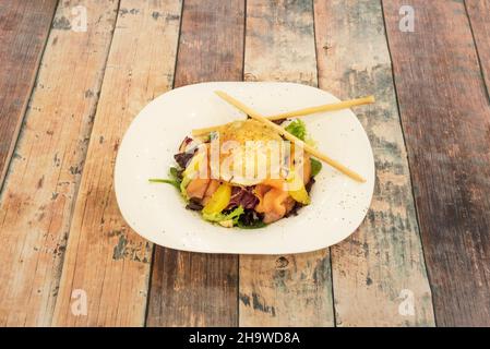 Insalata di salmone norvegese con formaggio di capra gratinato e pezzi d'arancia con pepe Foto Stock