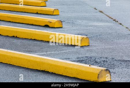 Parcheggio bar nella zona vicino al centro commerciale. Parcheggio all'aperto con barre di cemento gialle. Vista stradale, fuoco selettivo, nessuno Foto Stock