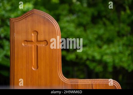 Uno sguardo ravvicinato alla graziosa croce sul lato di un'arpia della chiesa. Si siede fuori in una bella giornata di primavera per riflettere su Dio nostro Creatore. Effetto bokeh Foto Stock