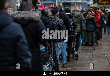 Stoccarda, Germania. 04th Dic 2021. Numerose persone attendono nel centro di Stoccarda di fronte a un centro di vaccinazione per la vaccinazione di Corona, che potrebbe essere ottenuta senza appuntamento. Il consiglio degli anziani di Stato chiede che agli anziani venga risparmiata la lunga attesa e che venga data priorità. (Al dpa/lsw 'Consiglio degli anziani dello stato: Diritto di strada per gli anziani nelle code di vaccinazione ') credito: Christoph Schmidt/dpa/Alamy Live News Foto Stock