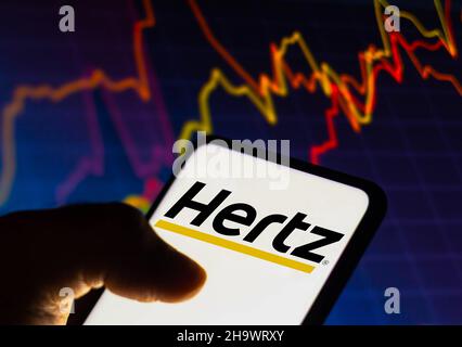 Brasile. 08th Dic 2021. In questa foto è illustrato il logo Hertz Corporation visualizzato su uno smartphone con un grafico del mercato azionario sullo sfondo. (Foto di Rafael Henrique/SOPA Images/Sipa USA) Credit: Sipa USA/Alamy Live News Foto Stock