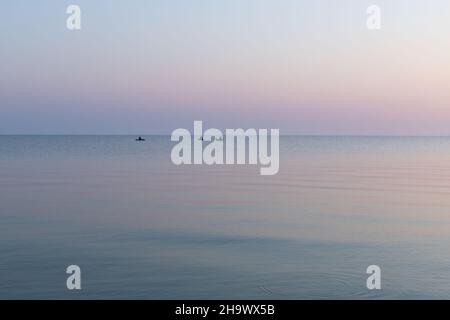 Mare all'alba con tre barche di gomma da pesca, calma, Mare di Azov, Russia. Foto Stock