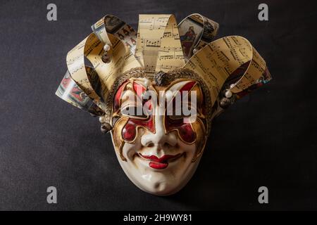 Maschera harlequin veneziana Carnival su sfondo nero. Commedia dell'arte personaggio masquerade. Tradizionale festa travestito, Foto Stock