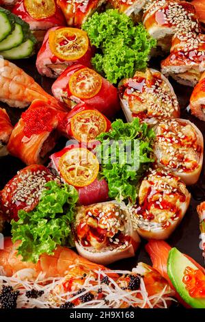 Primo piano di vari sushi rotolini giapponesi con salmone, tonno, anguilla e gamberetti Foto Stock