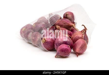 Primo piano su cipolle rosse organiche o scalogni da da borsa a rete o borsa a rete per la vendita nel mercato, immagine su sfondo bianco. Foto Stock