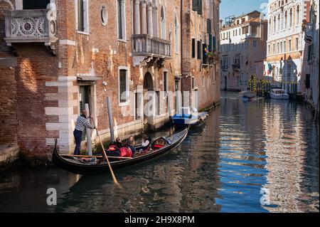 Venezia, Italia - 27 ottobre 2021: Canal con gondola a Venezia (Italia) in inverno, vecchie case Foto Stock