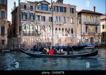 Venezia, Italia - 27 ottobre 2021: Gondola con turisti sul canale Grande a Venezia in inverno, vecchie case Foto Stock