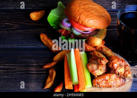 hamburger con patate fritte e bevande fritte e ali di pollo fritte Foto Stock