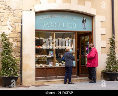 Clienti al di fuori di un piccolo panificio nel villaggio di Elceigo, Álava, Paesi Baschi, Spagna settentrionale Foto Stock