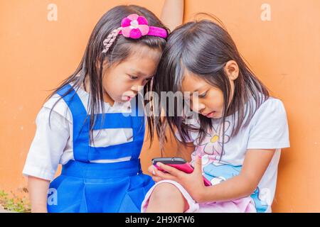 SAGADA, FILIPPINE - 24 GENNAIO 2018: Ragazze giovani con uno smartphone nel villaggio di Sagada sull'isola di Luzon, Filippine Foto Stock