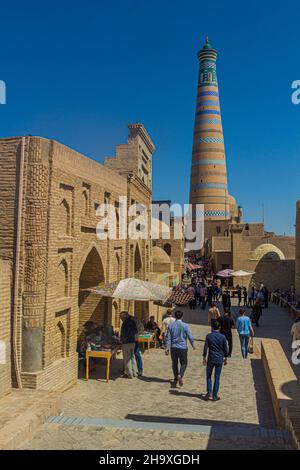 KHIVA, UZBEKISTAN - 26 APRILE 2018: Mercato di strada nella città vecchia di Khiva, Uzbekistan. Islam Khoja minareto sullo sfondo. Foto Stock