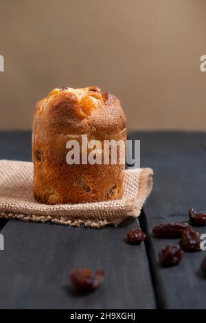 Dessert italiano mini panettone con uvetta su sfondo di legno scuro, orientamento verticale Foto Stock