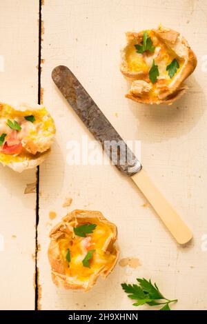 Toast quiches (fette di toast cotte in una teglia per cupcake e fille con prosciutto, uovo e formaggio) Foto Stock