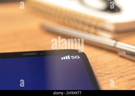 Telefono cellulare collegato al sistema wireless di rete 5G. Foto di sfondo del desktop aziendale Foto Stock