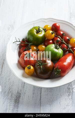 Diversi pomodori colorati sul piatto bianco Foto Stock