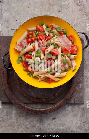 Insalata di pasta con penne, pomodori, piselli e prosciutto Foto Stock