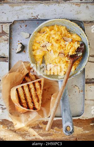 Uova strapazzate con tartufi in una padella con pane tostato Foto Stock