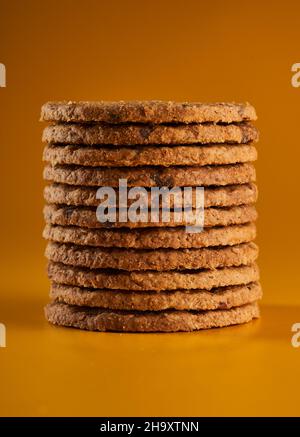 Primo piano dei biscotti digestivi all'avena integrale su sfondo giallo Foto Stock