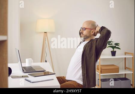 L'uomo stanco dorme alla scrivania dell'ufficio di casa Foto Stock