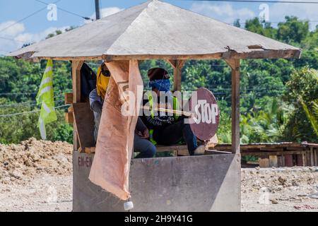 BOHOL ISLAND, FILIPPINE - 11 FEBBRAIO 2018: Due lavoratori locali della strada con un segnale di stop sull'isola di Bohol. Foto Stock