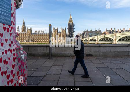 WESTMINSTER LONDRA, REGNO UNITO. 9 dicembre 2021. Un pedone passa accanto ai cuori dipinti al Muro commemorativo Nazionale di Covid lungo l'argine del Tamigi. il primo ministro Boris Johnson ha annunciato restrizioni più severe del piano B Covid durante un discorso televisivo da Downing Street il mercoledì sera, tra cui il lavoro da casa, indossare maschere e introdurre i passi Covid per combattere l'ascesa esponenziale della variante omicron alla luce dello scandalo del partito di Natale a Downing Street. Credit: amer Ghazzal/Alamy Live News Foto Stock