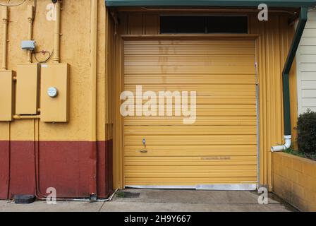 Porta garage sul magazzino e porta regolare sfondo industriale Foto Stock