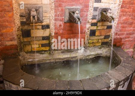 Una fontana con dhunge dharas o beccucci a forma di mitica makara o coccodrillo nella mitologia indù. Kathmandu, Nepal Foto Stock