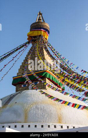 La cupola, l'harmika e la guglia del Boudhanath Stupa con bandiere di preghiera e gli occhi di Buddha. Kathmandu, Nepal. Foto Stock