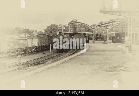 L'immagine da un negativo monocromatico scansionato è della stazione ferroviaria di Alnwick nel Northumberland come era nel luglio 1957 con il treno a vapore 64916 in posizione inattiva Foto Stock
